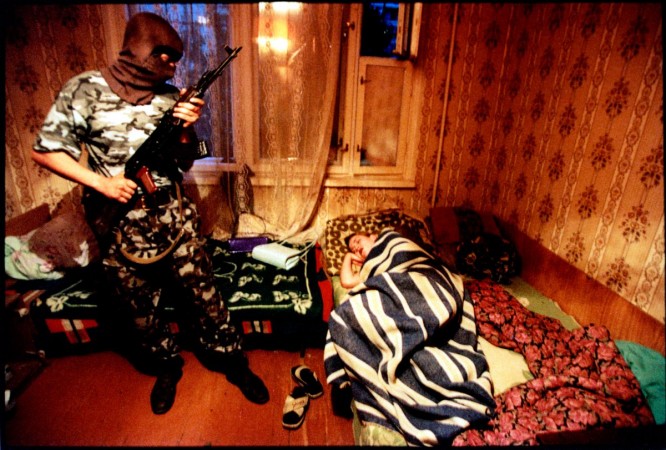 Putin's Russia - The Darkness of Russia June 2001 Volgograd, Russia Drug raid, the OMON squad is a special purpose police unit, militia-comando outfit. They wear military style uniforms and sometimes masks, blue flak jackets and carry machine pistols, AK-47's.